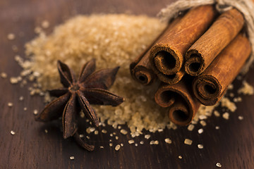 Image showing Cinnamon sticks with pure cane brown sugar on wood background