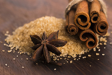 Image showing Cinnamon sticks with pure cane brown sugar on wood background