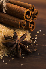 Image showing Cinnamon sticks with pure cane brown sugar on wood background