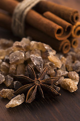 Image showing Cinnamon sticks with pure cane brown sugar on wood background