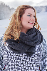 Image showing Portrait of a blond chubby woman in winter jacket and thick scarf.