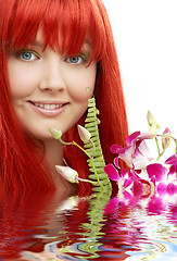 Image showing lovely redhead with orchid in water