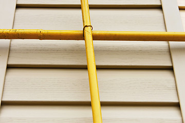 Image showing Two gas pipes over the siding wall