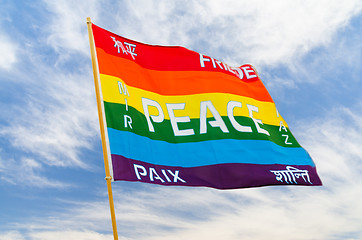 Image showing Rainbow multiolored peace flag wind flying against blue sky