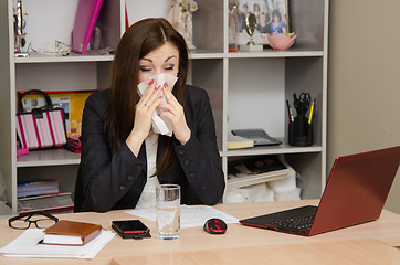 Image showing The girl wiping nose with a tissue in the office