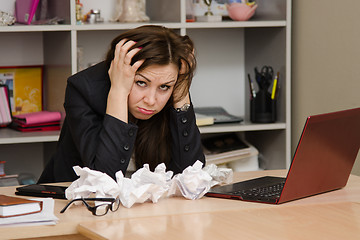 Image showing The girl at the computer holding head in his hands