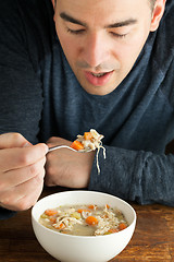 Image showing Man Eating Homemade Chicken Soup