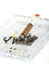 Image showing Cigarillos, burnt match in a crystal ashtray.