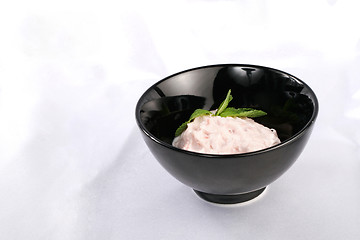 Image showing Black plate with cream pink sauce