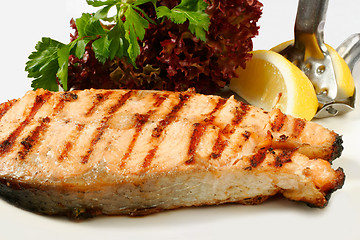 Image showing Grilled salmon steak with salad and lemon