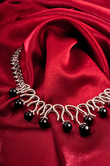 Image showing Black pearls on red textile