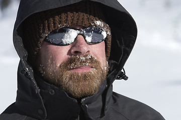 Image showing Young man with snow in his face looks into the distance 