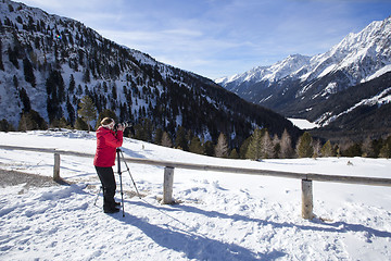 Image showing Female photographer takes pictures in wintry mountanin landscape