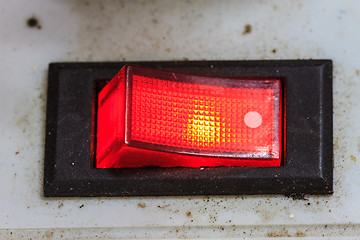 Image showing device panel with detailed red power switch button 