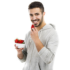 Image showing Happy young eating a strawberry