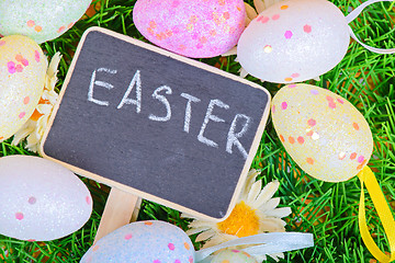 Image showing Easter eggs with chalkboard on the grass