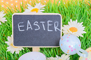 Image showing Easter eggs with blackboard on the grass