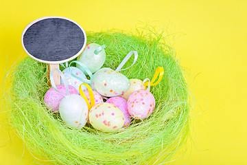 Image showing Ester eggs in green nest with copy-space board
