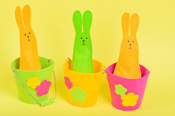 Image showing Three easter Bunnys in buckets on yellow