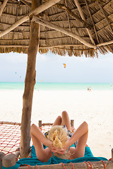 Image showing Woman sunbathing on tropical beach.