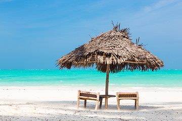 Image showing Two deck chairs and umbrella on tropical beach.