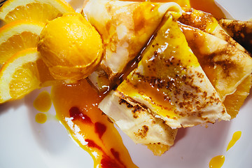 Image showing stuffed pancakes with orange syrup and ice-cream