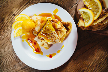 Image showing stuffed pancakes with orange syrup and ice-cream