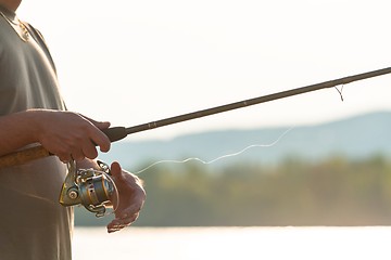 Image showing Modern clean fishing rod in hands