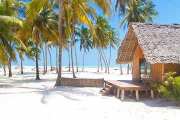 Image showing Wooden bungalow on tropical white sandy beach. 