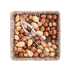 Image showing Mixed nuts in a woven basket with nut cracker