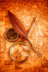 Image showing Vintage magnifying glass lies on an ancient world map