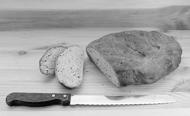 Image showing Bread knife with slices of bread cut from a loaf