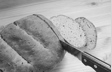 Image showing Cutting slices of bread on a wooden table