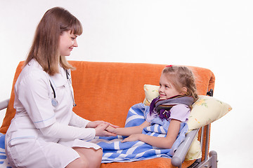 Image showing Pediatrician looks at the sick child and keeps his hand