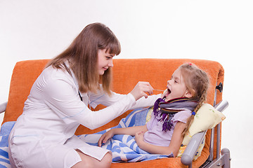 Image showing Pediatrician looks at the throat of a sick child