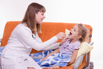 Image showing The doctor examines the throat Sick little girl in bed