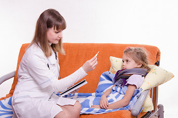 Image showing Pediatrician about sick girl looking at a thermometer