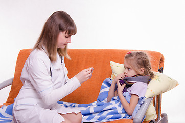 Image showing Doctor near sick girl looking at a thermometer