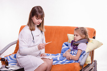 Image showing Doctor looking baby temperature on a thermometer