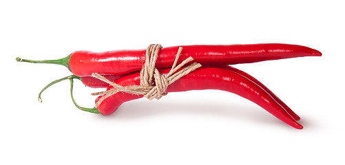 Image showing Three red chili peppers tied with a rope reversed