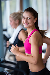 Image showing friends  exercising on a treadmill at the bright modern gym