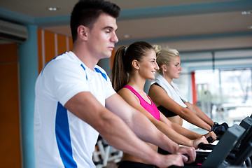 Image showing friends  exercising on a treadmill at the bright modern gym