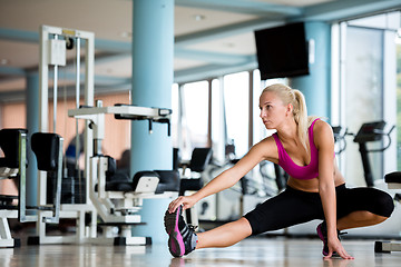 Image showing woman stretching and warming up for her training at a gym