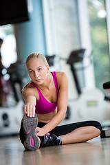 Image showing woman stretching and warming up for her training at a gym