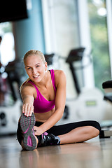 Image showing woman stretching and warming up for her training at a gym