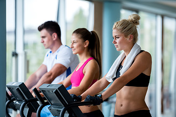 Image showing friends  exercising on a treadmill at the bright modern gym