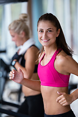 Image showing friends  exercising on a treadmill at the bright modern gym