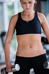 Image showing lifting some weights and working on her biceps in a gym