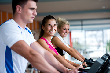 Image showing friends  exercising on a treadmill at the bright modern gym