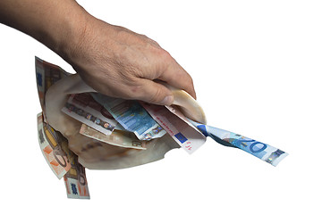 Image showing a hand is holding a sea shell with money white background.